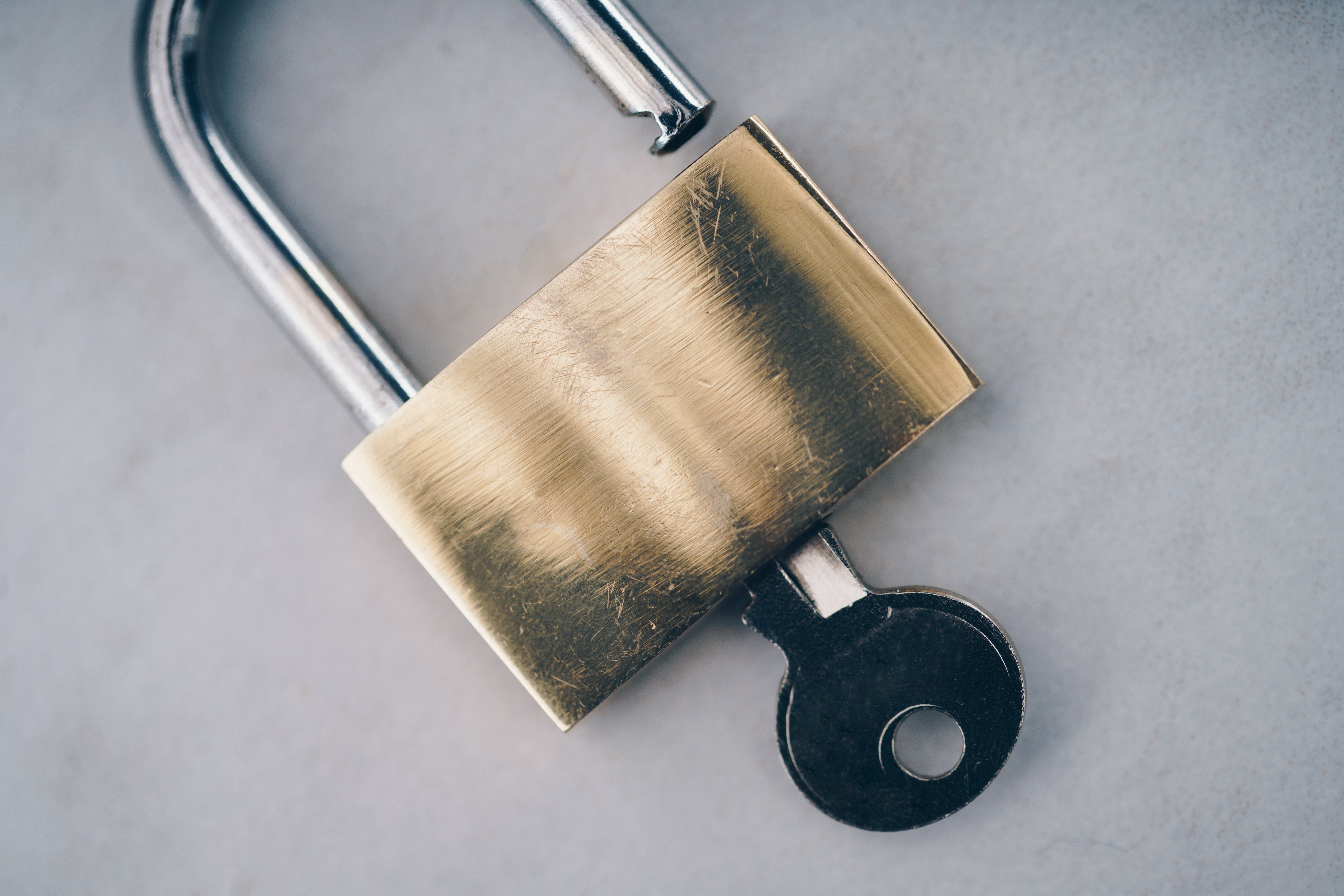 Metal key inserted into a padlock, showing how a physical key controls access